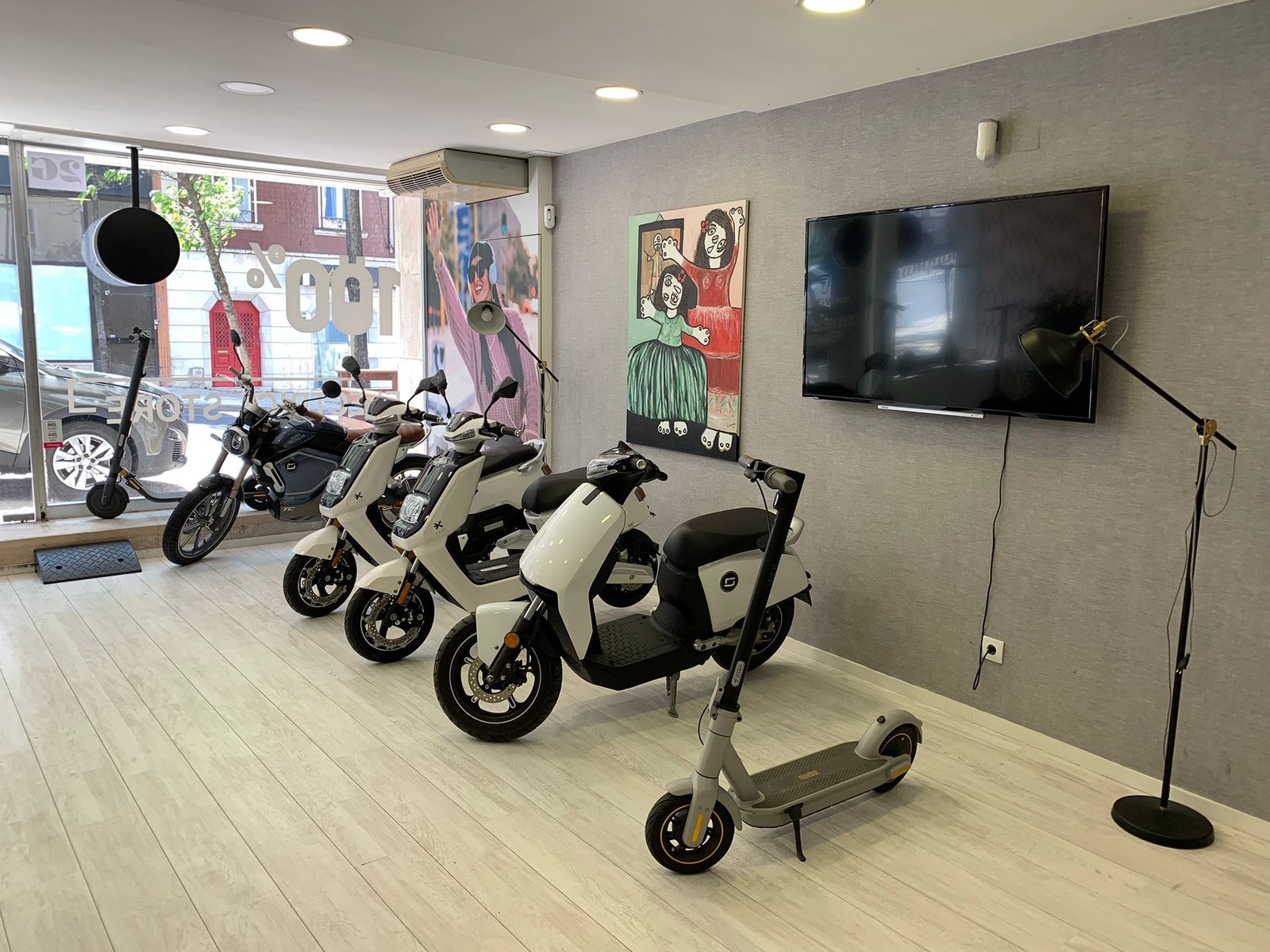 Motos e trotinetes elétricas da frota YesMobi alinhadas no espaço em Cascais
